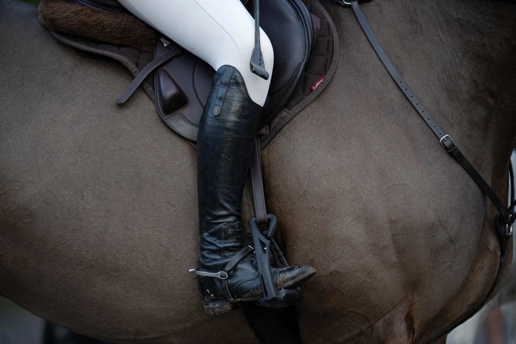 Closeup of a rider&#x27;s foot on the stirrups of a horse