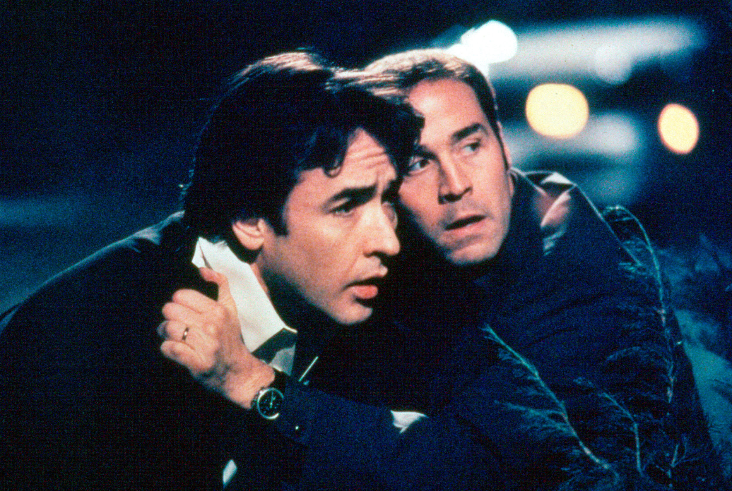 John Cusack and Jeremy Piven grab one another while hiding