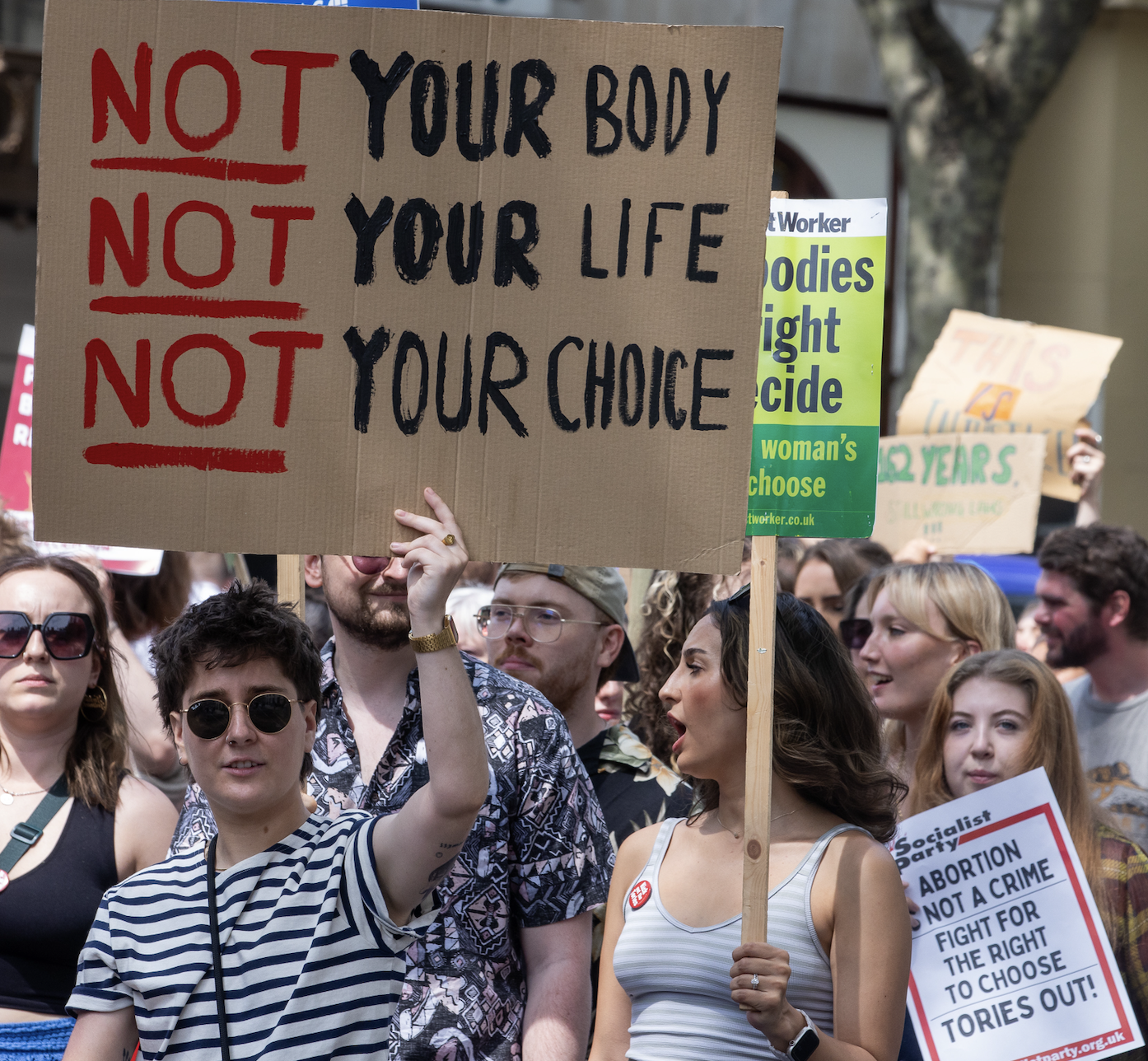 Protestor with sign that reads &quot;not your body, not your life, not your choice&quot;