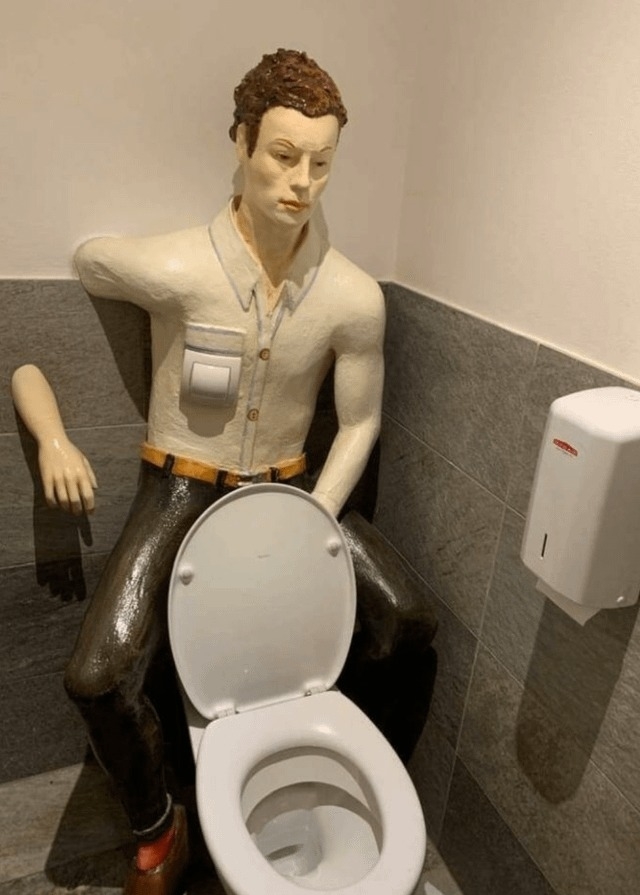 A fake man behind a toilet