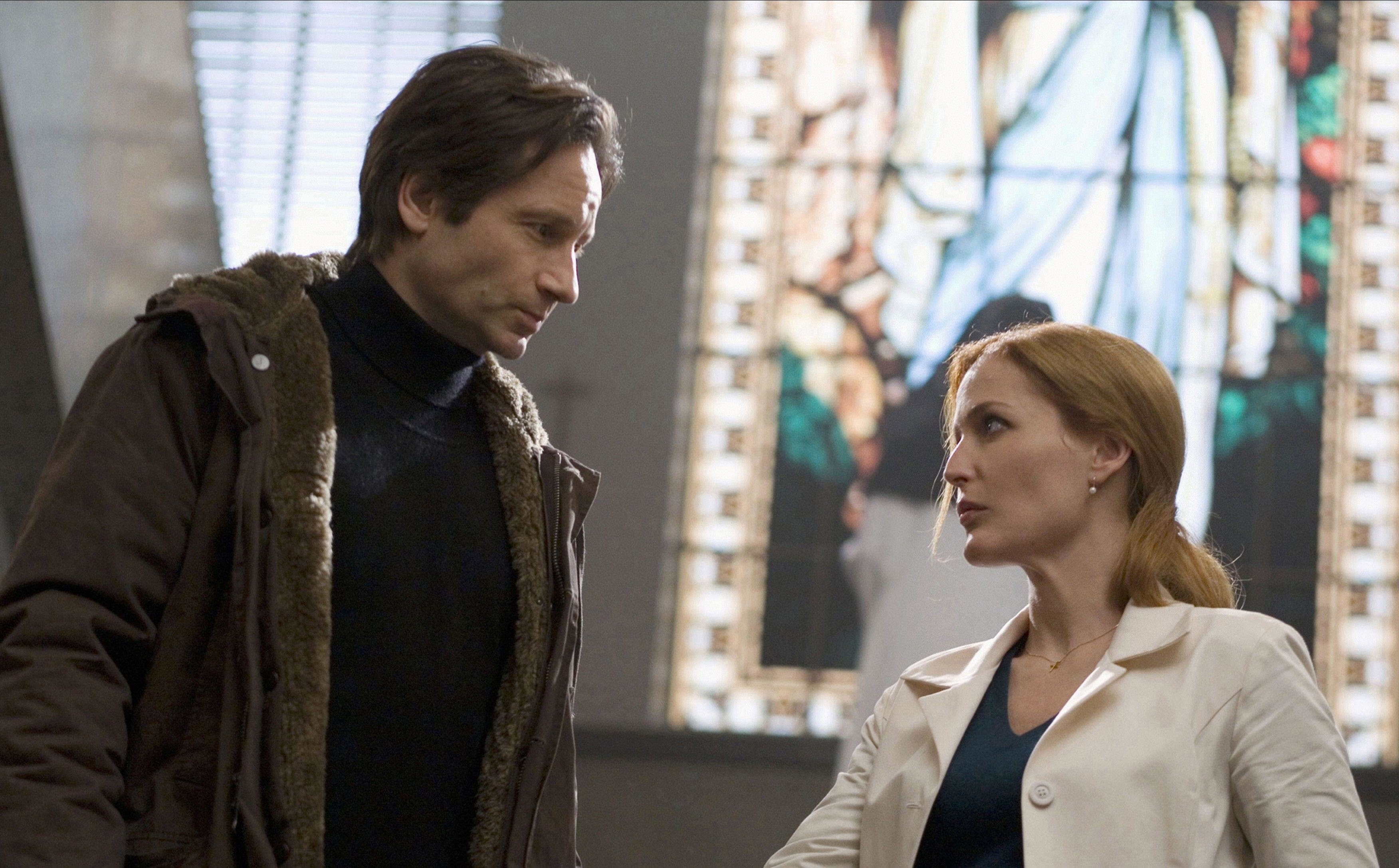 David Duchovny and Gillian Anderson trade an intense stare in a church