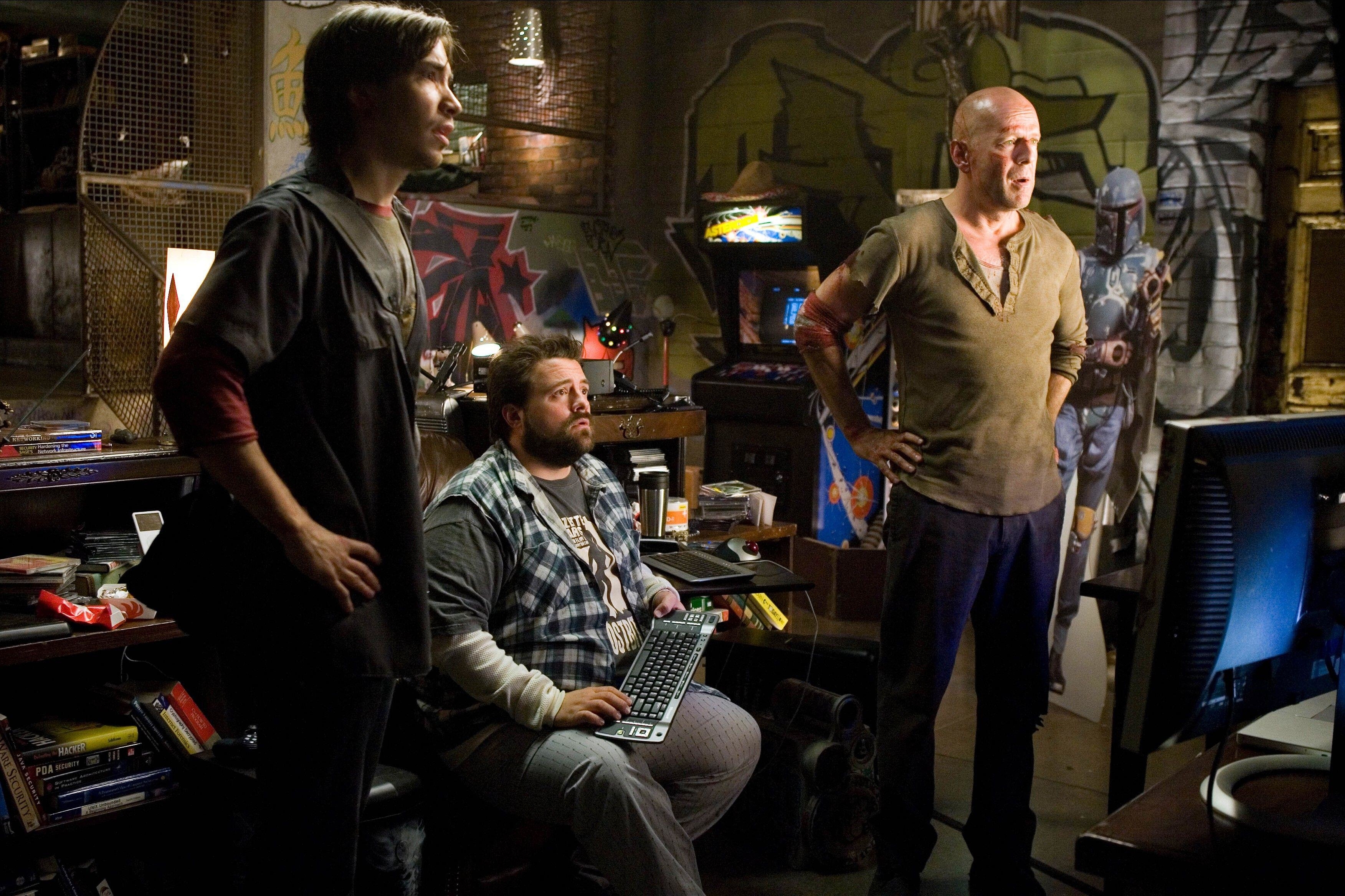 Justin Long, Kevin Smith and Bruce Willis sit in a nerdy basement