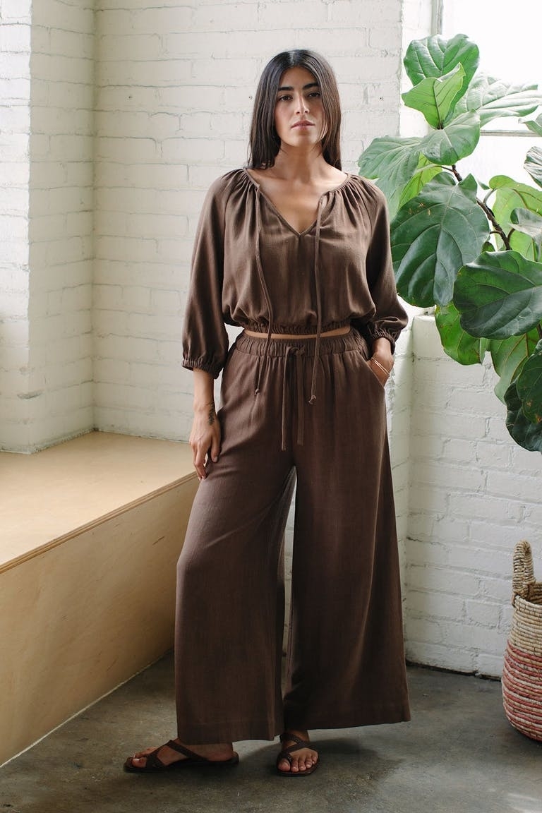model in chocolate brown wide-legged linen drawstring pants