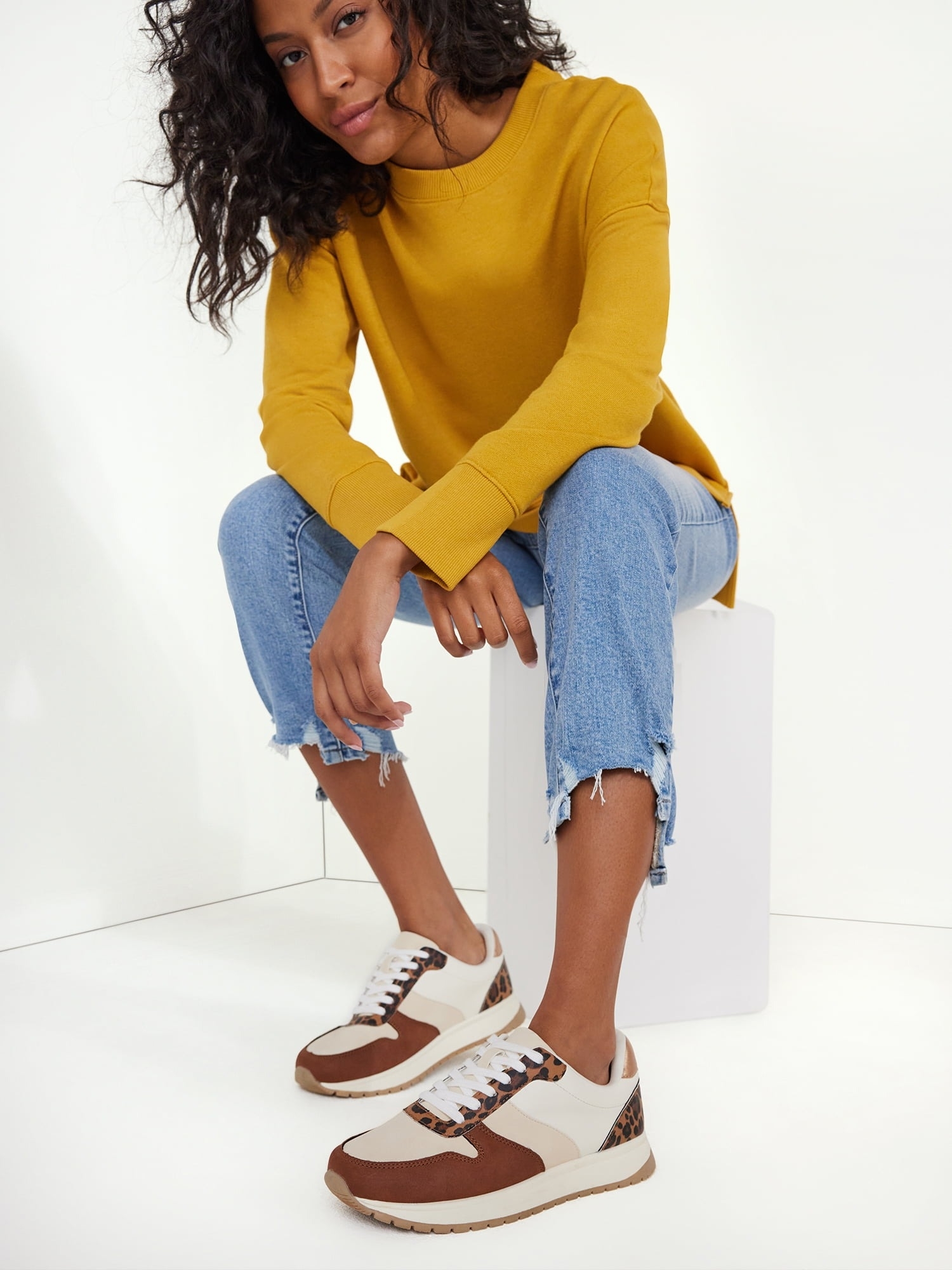 a model wearing the brown, tan, white and leopard sneakers