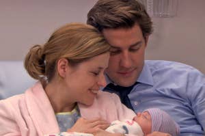 Jim and Pam from The Office lying in a hospital bed, holding their baby