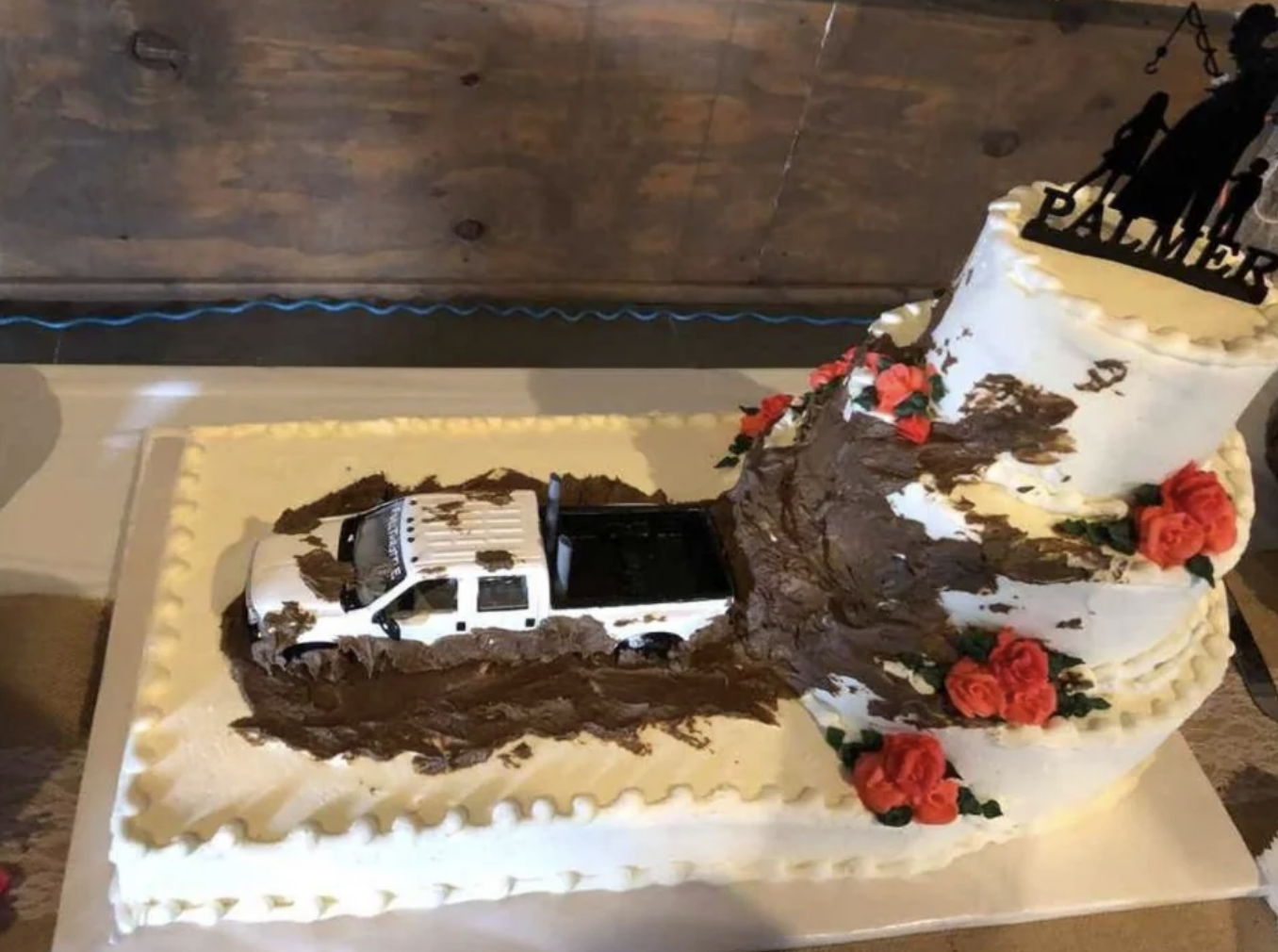 A wedding cake with a truck in mud on it