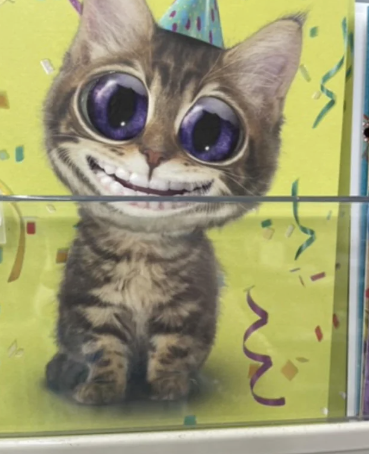 A scary, smiling cat with huge eyes and human teeth on a card