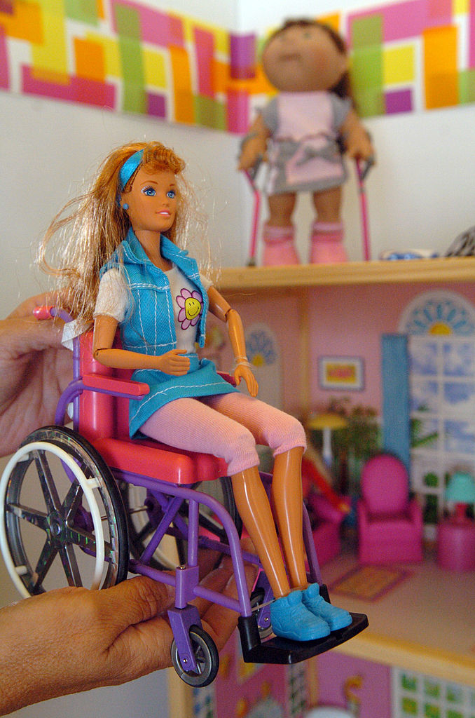 child playing with a barbie in a wheelchair