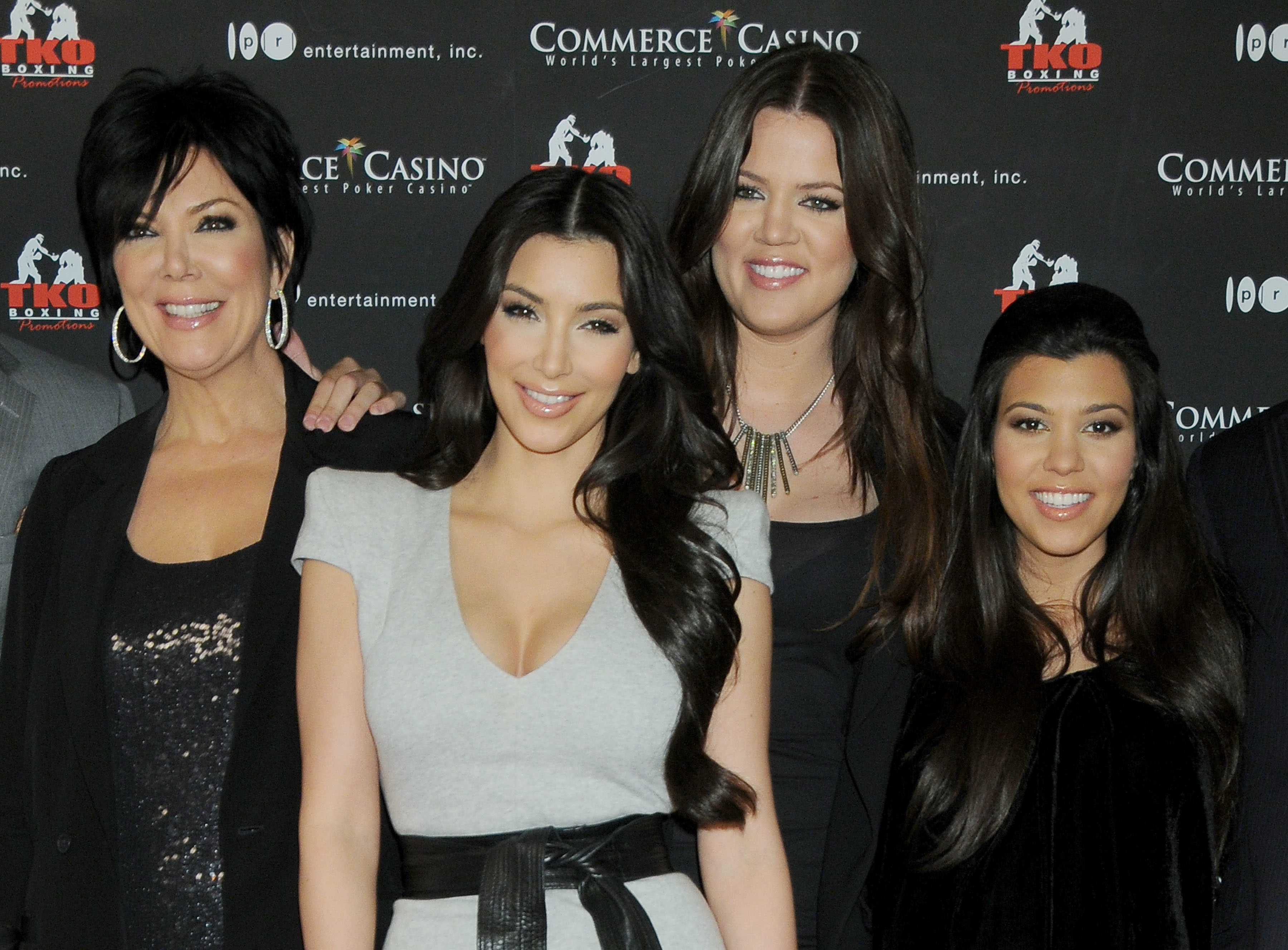 Close-up of Kris, Kim, Khloé, and Kourtney smiling at a media event