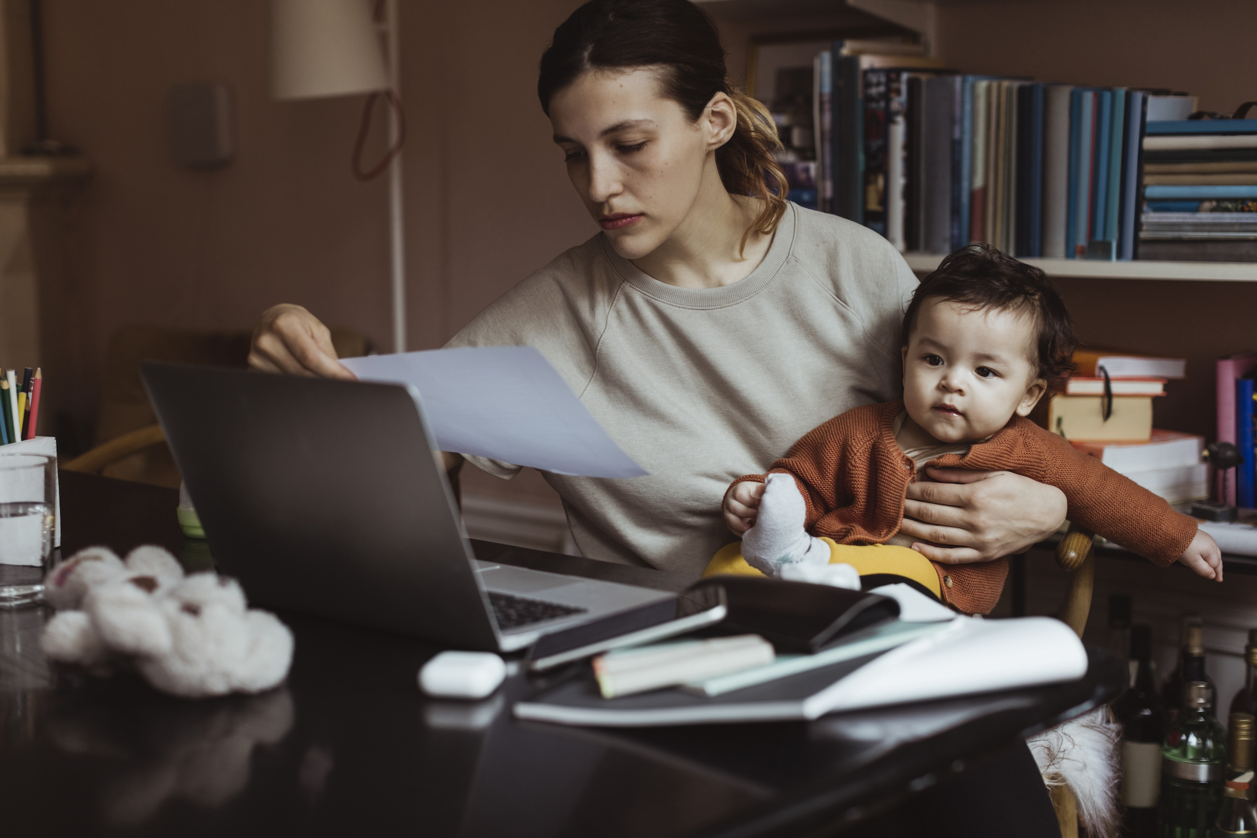 A mother with her child in her lap, in front of her computer