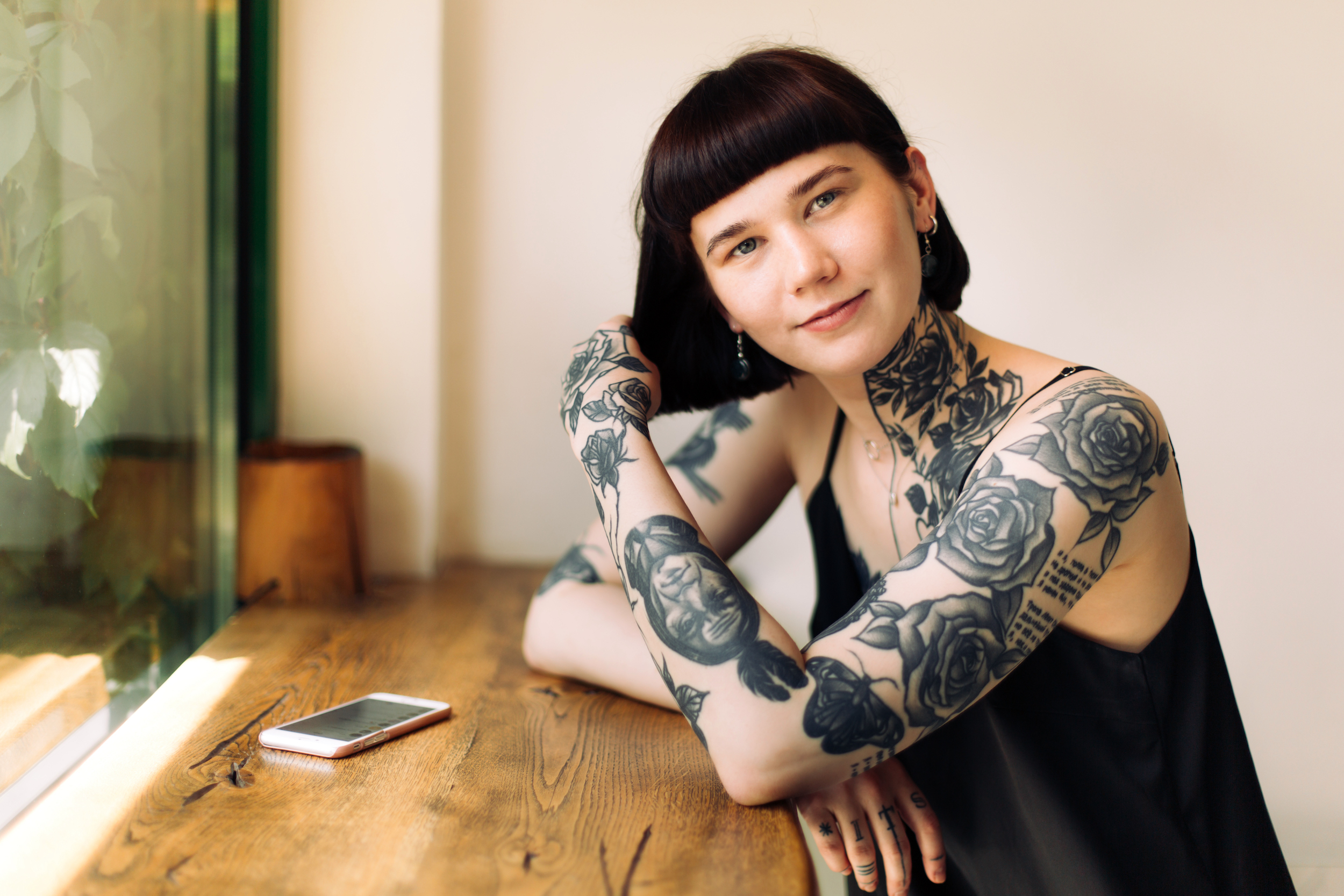 A woman with tattoos smiling