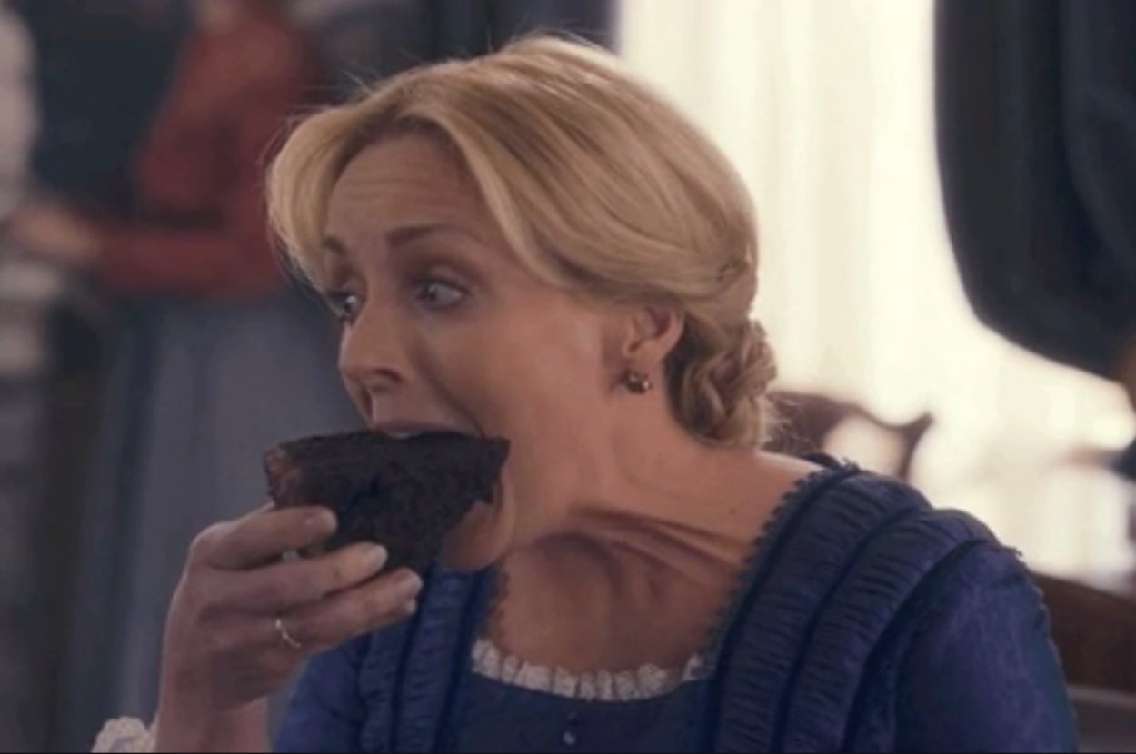 Jane Krakowski eating a slice of chocolate cake as Emily in Dickinson