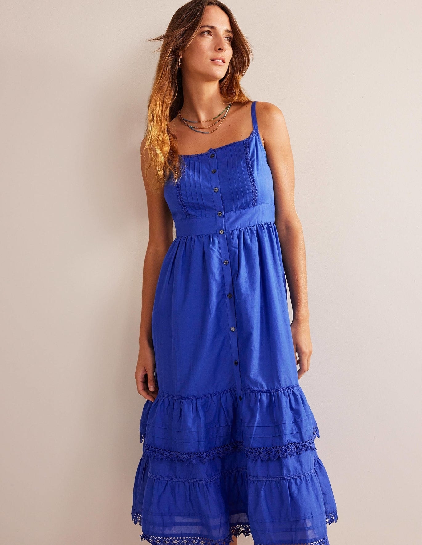 A model wearing a ruffled blue dress.