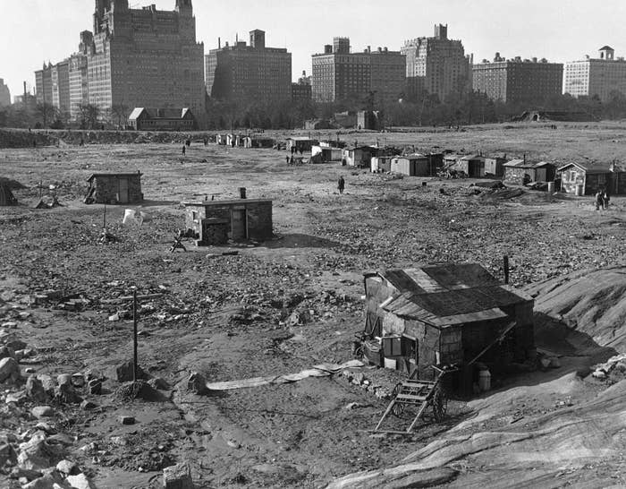 A dirt- and rock-covered area with some small, hut-type houses on it