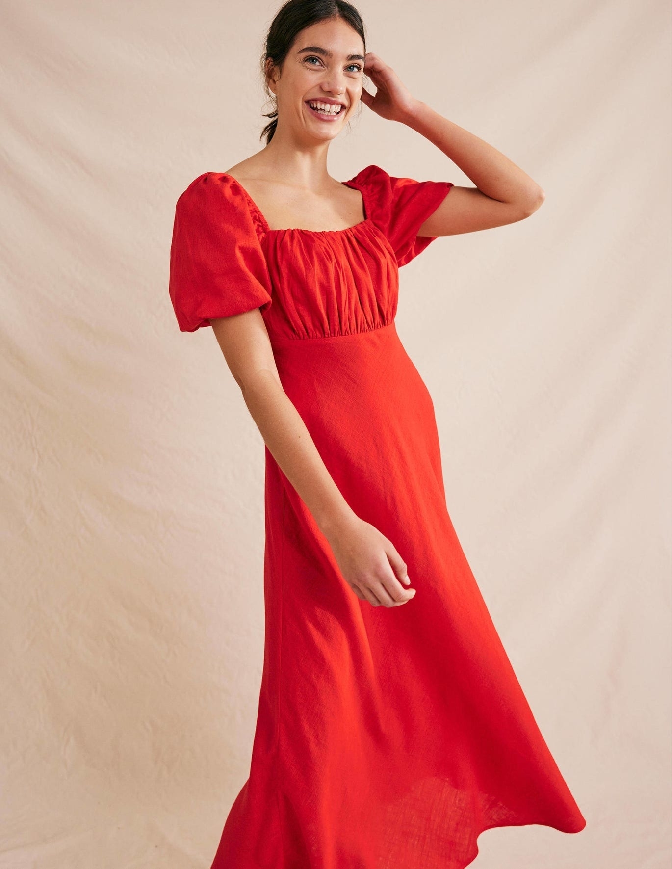 model wearing red short sleeve ruched puff midi dress