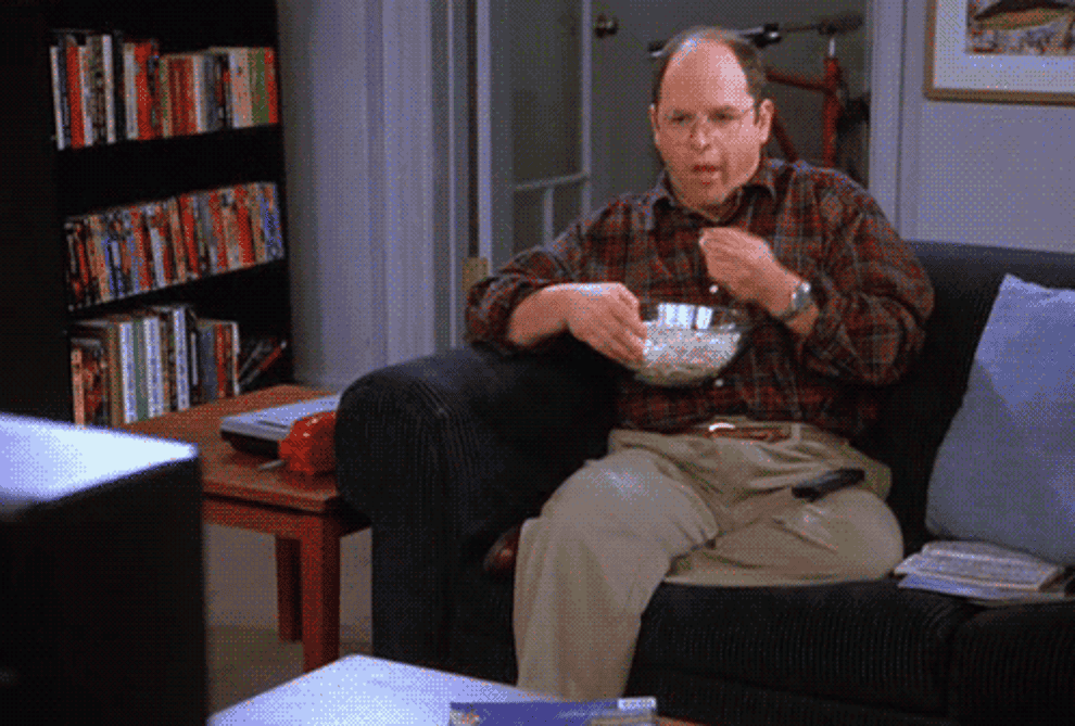 george costanza from seinfeld watching tv and eating popcorn