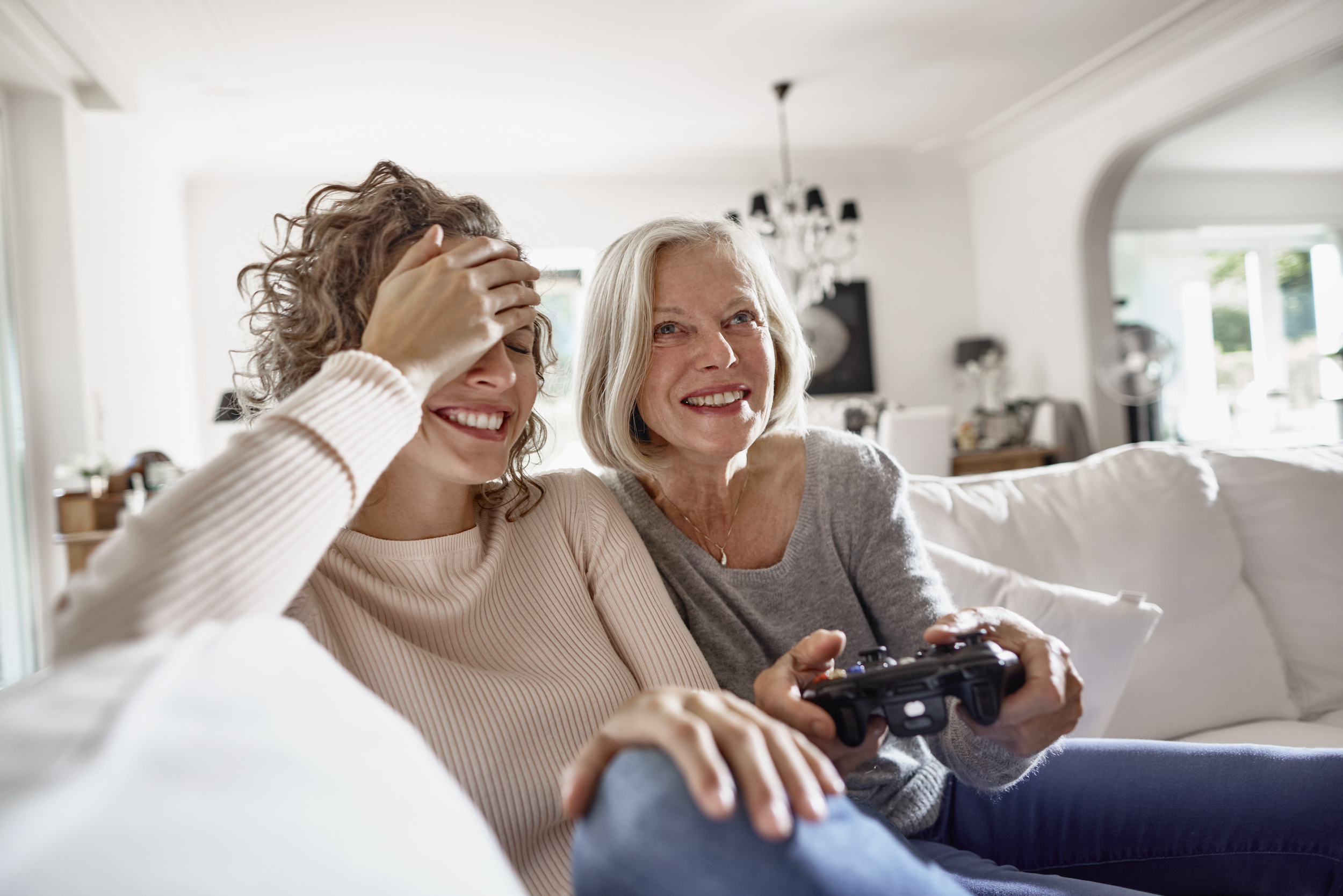 Two women laughing and playing a video game