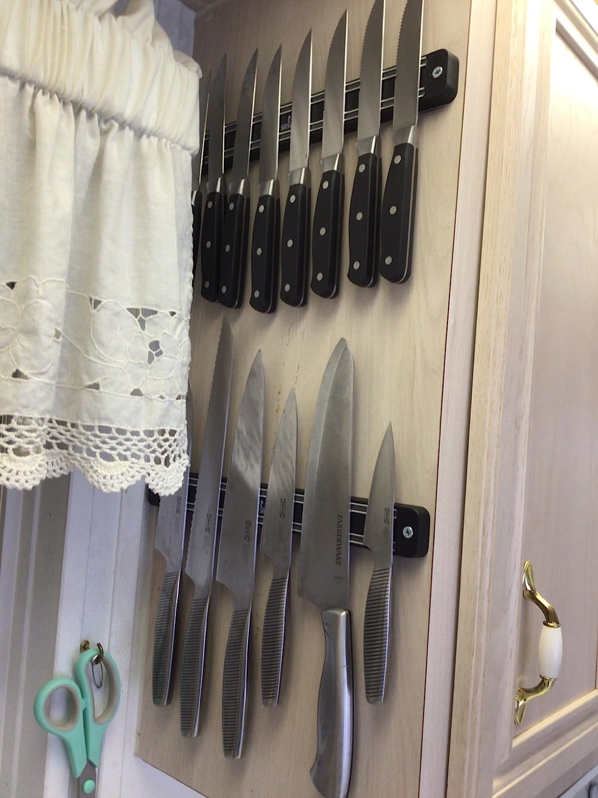 Reviewer&#x27;s photo of two of the knife bars mounted on a wall and holding many knives