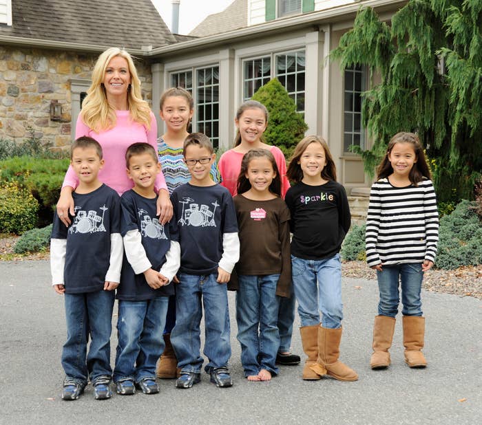 kate standing outside of her house with all her young children