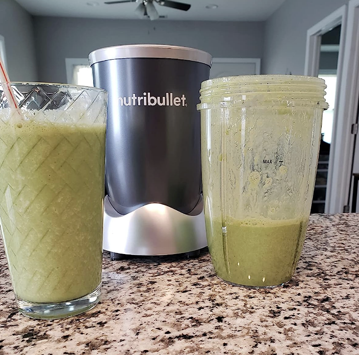 a nutribullet blender next to two green smoothies