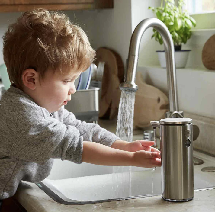 a child using a stainless steel soap dispenser