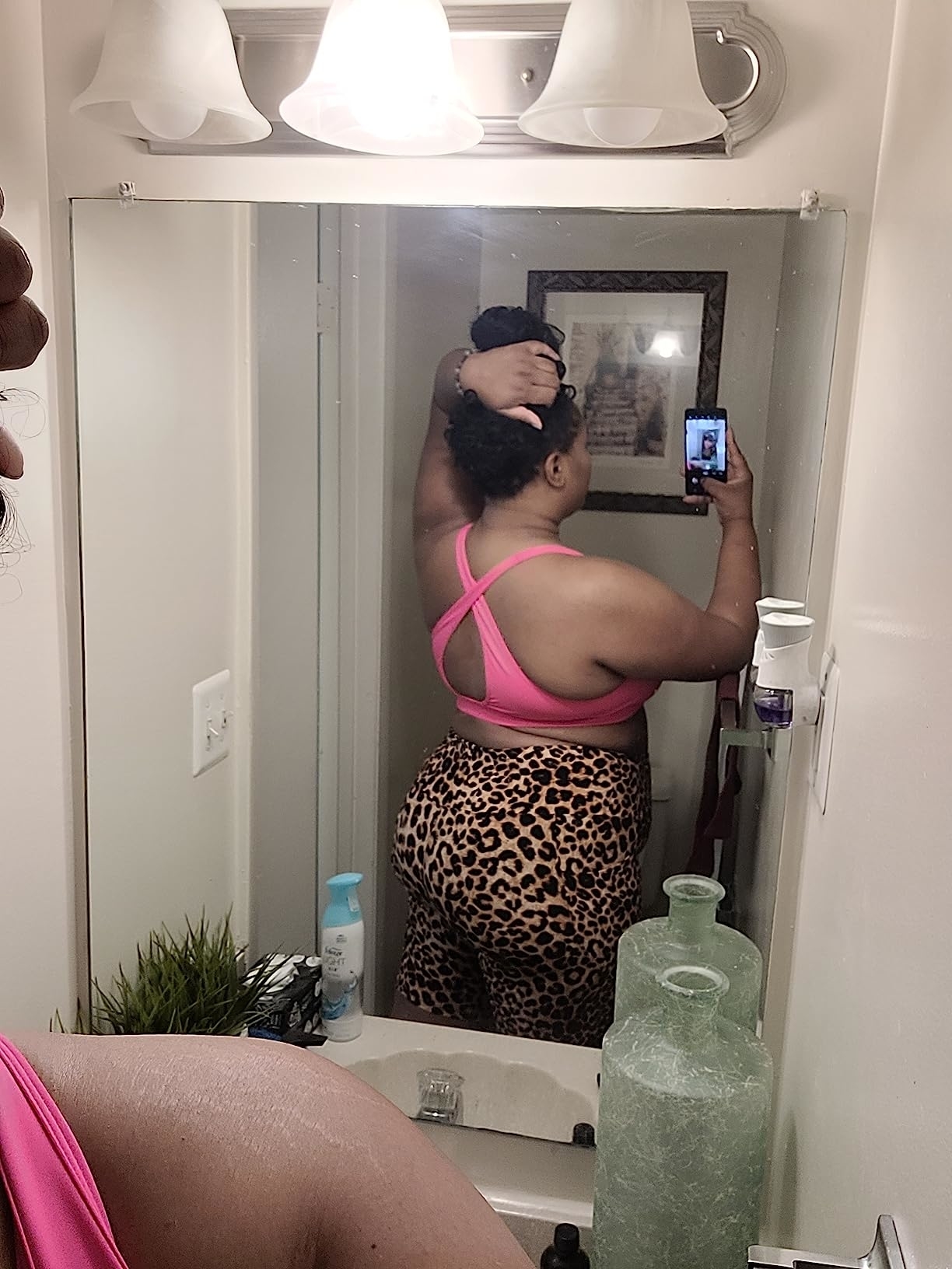 A reviewer wearing cheetah print shorts with a pink top
