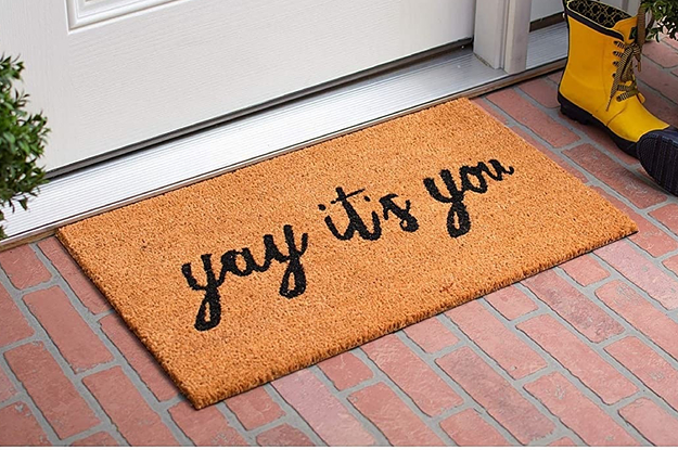 "Yay It's You" welcome mat in front of a door