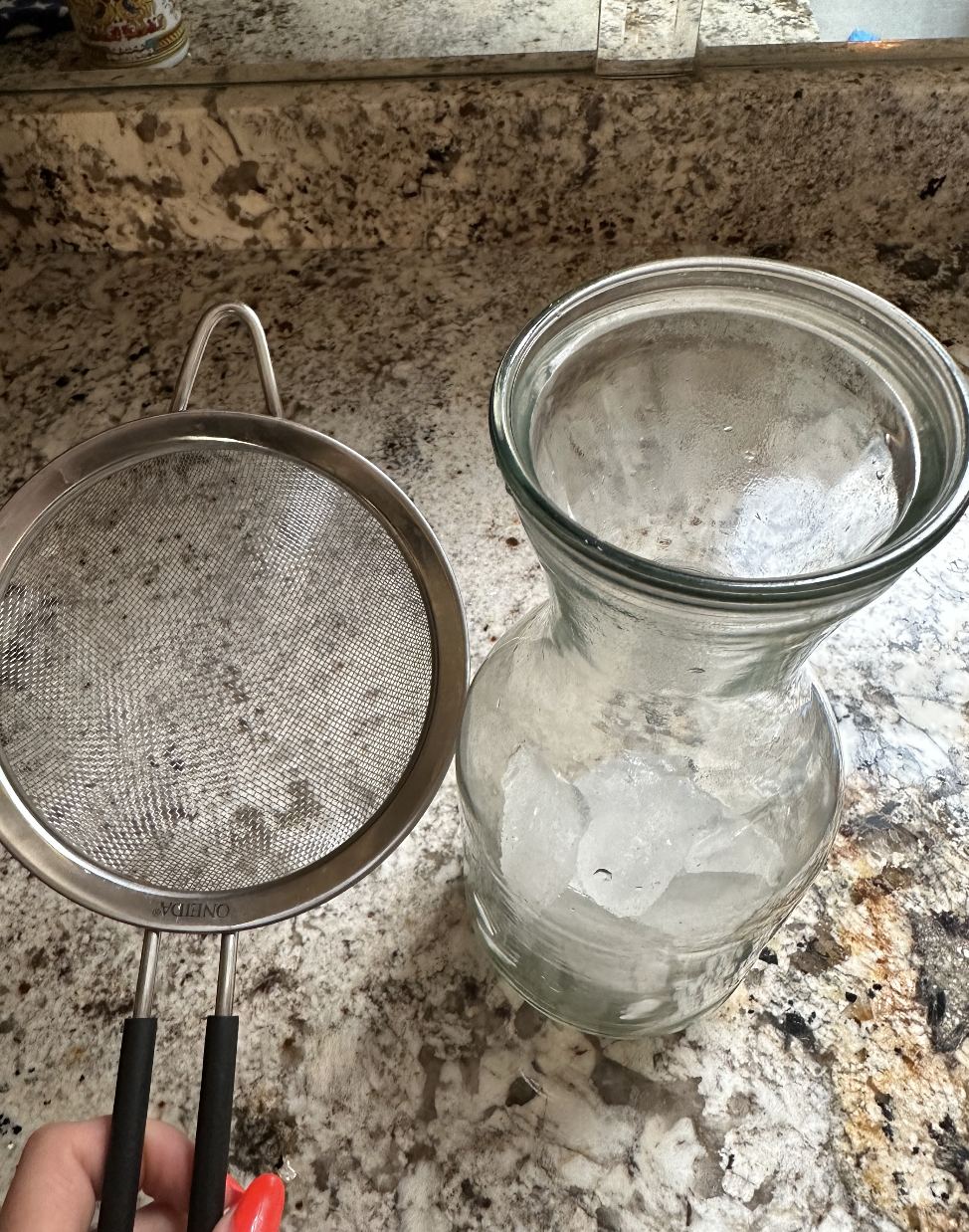 a strainer and a pitcher of ice