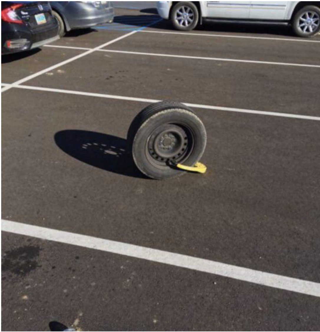 booted tire left in the parking lot