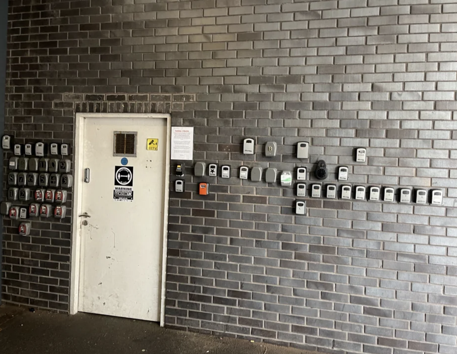 There are approximately 15 key safes installed on the wall that look exactly the same and all match the description provided