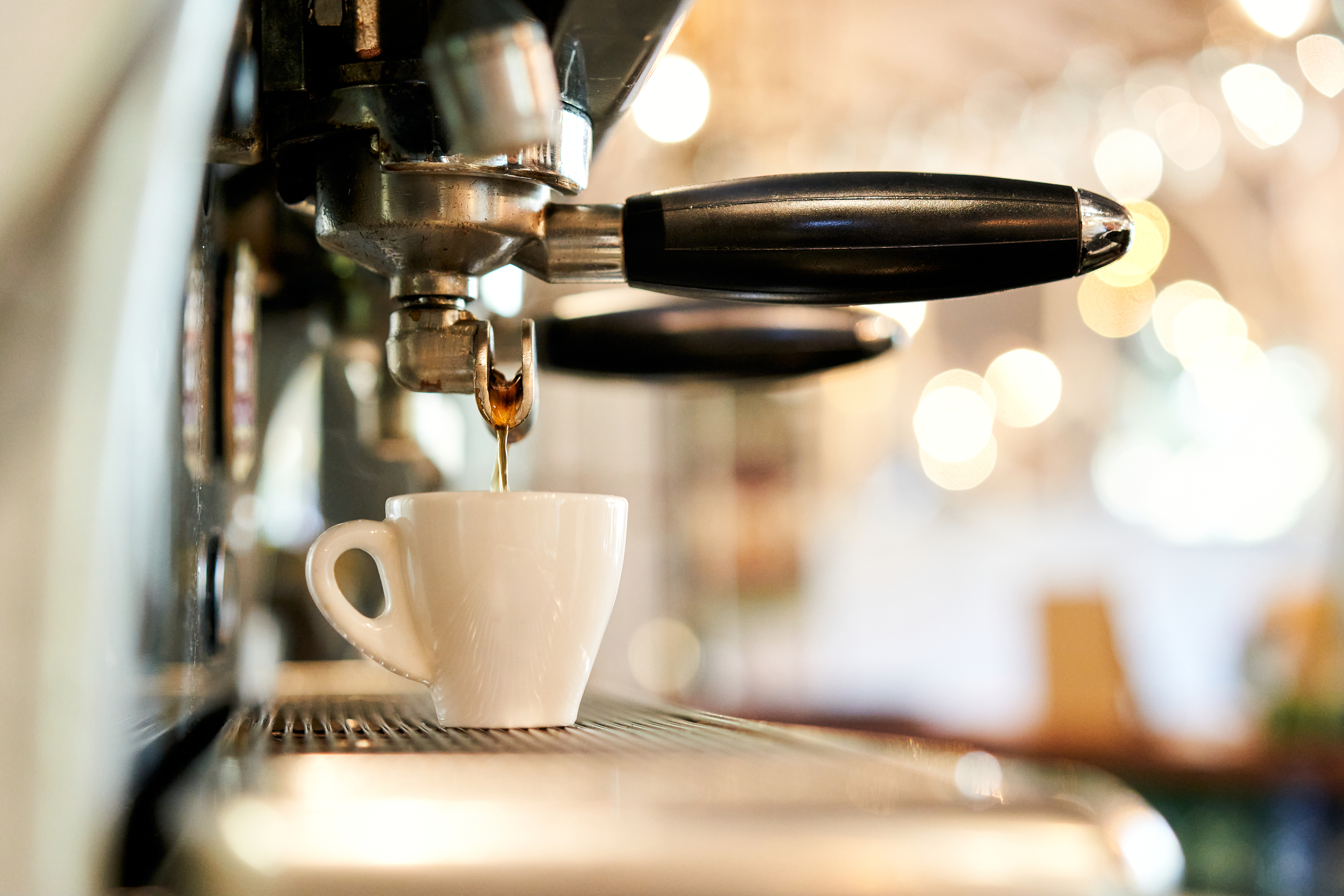 Espresso machine pouring coffee into a small cup