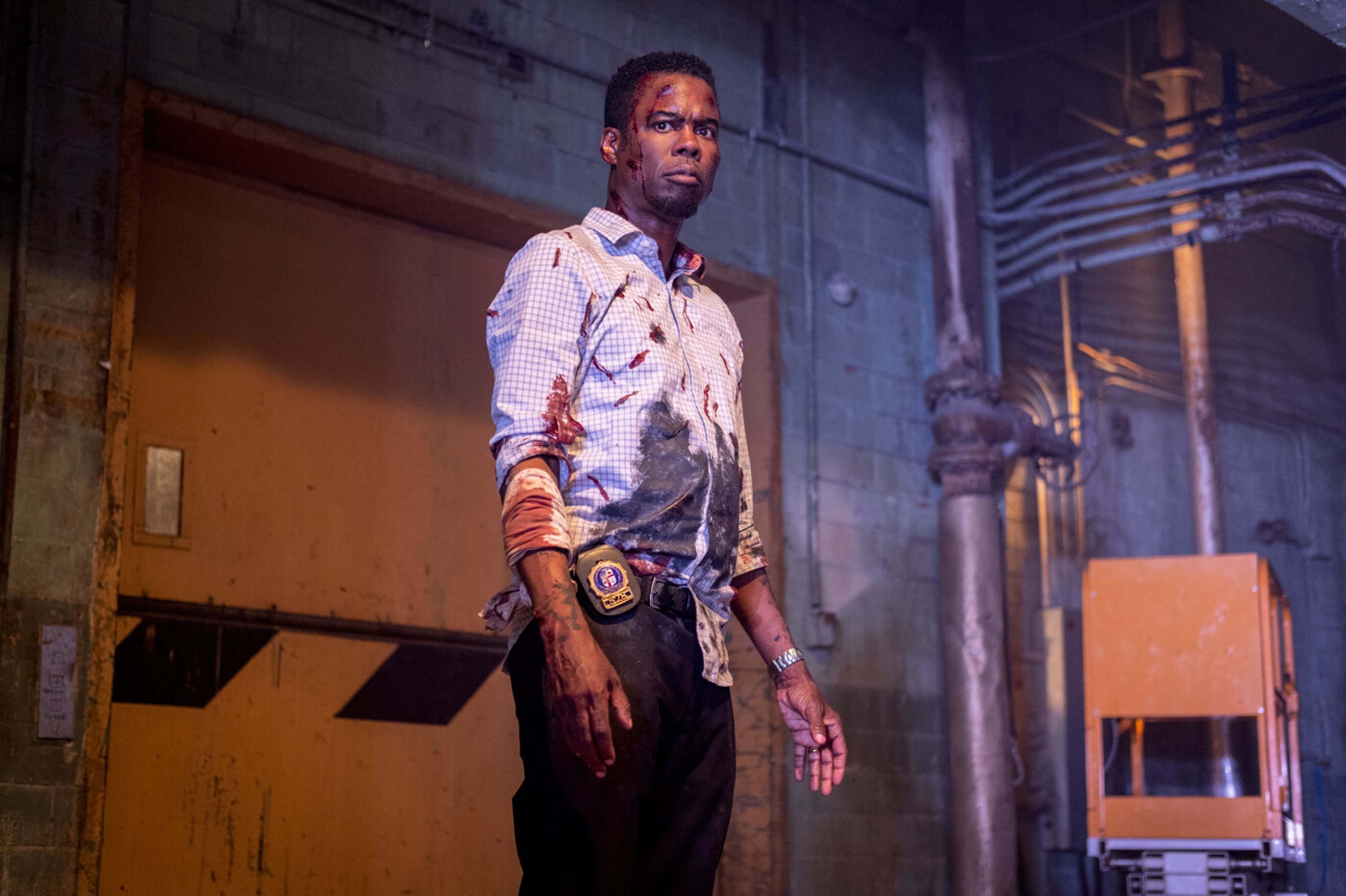 A bloodied Chris Rock stands near a freight elevator