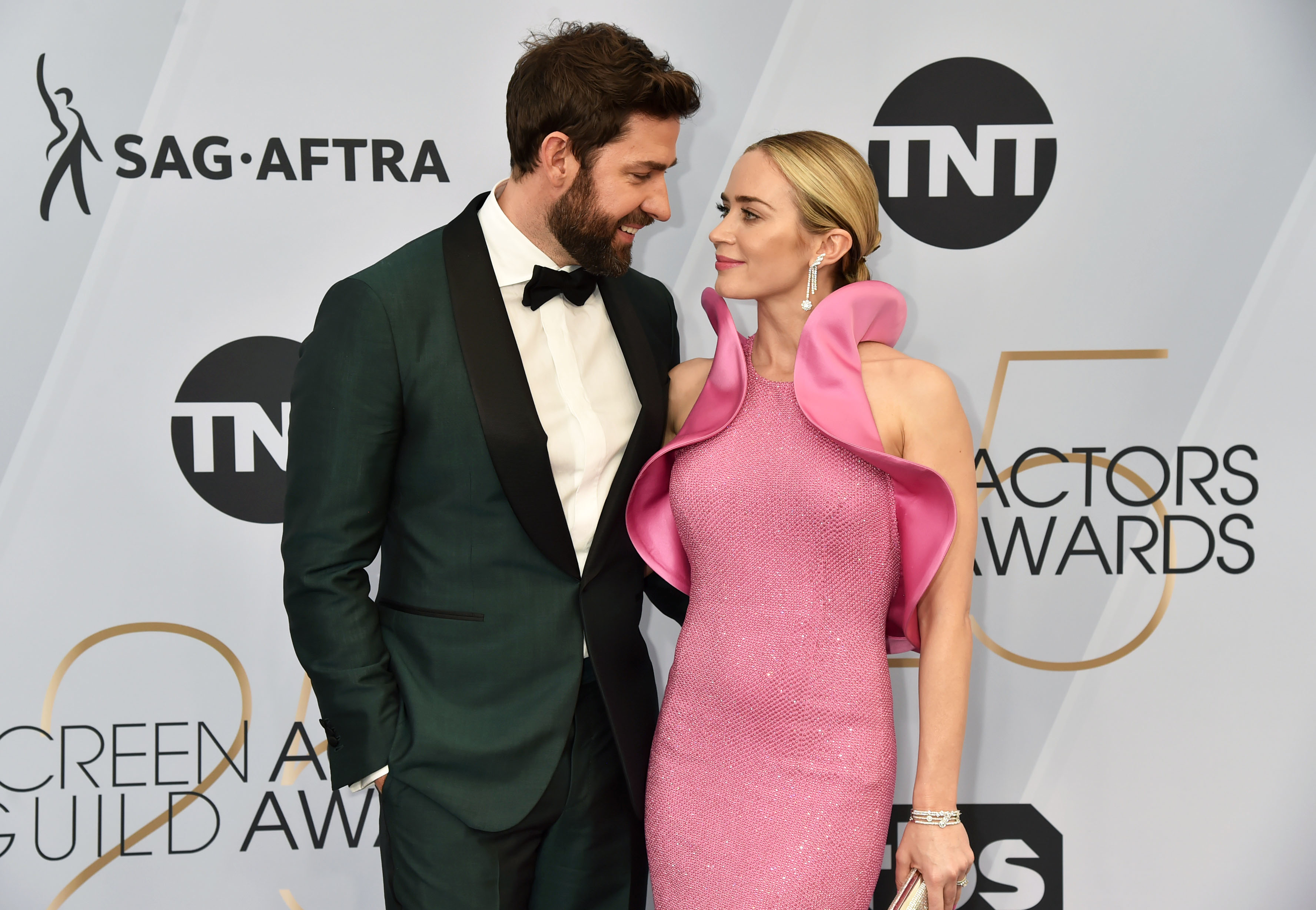 John and Emily look into each others eyes during an award ceremony red carpet