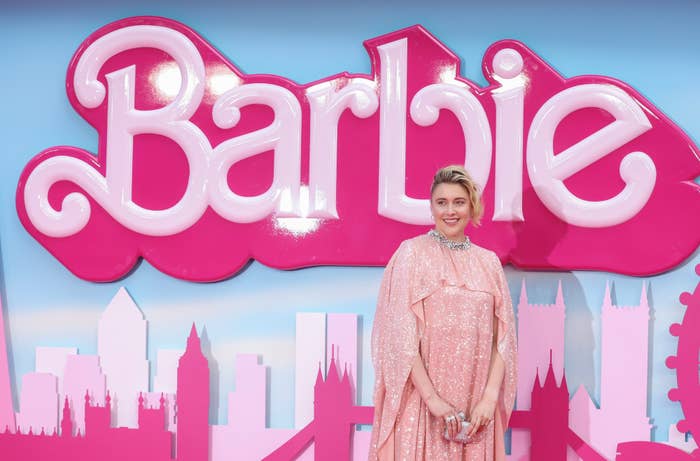 Greta Gerwig in front of the Barbie logo
