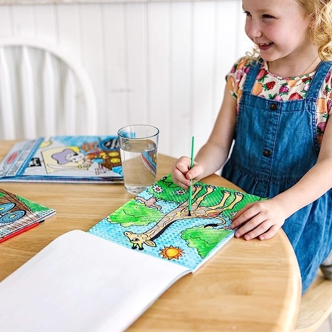 Child paints with water in a book
