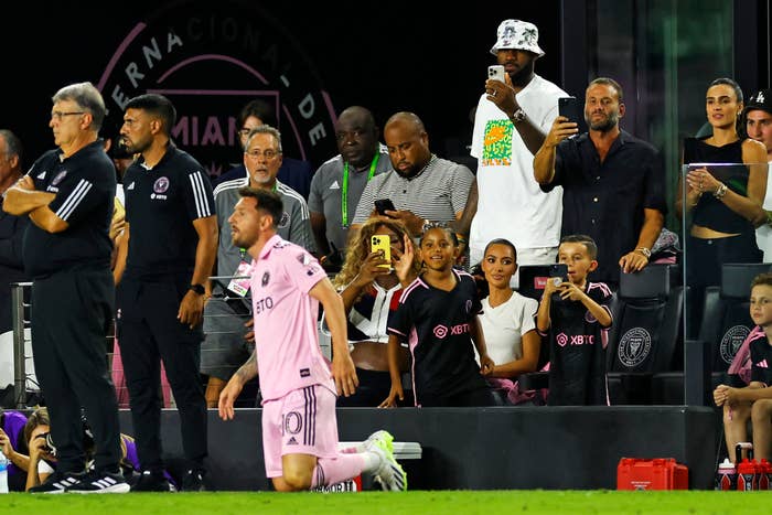 A crowd, including Kim Kardashian, watching the game