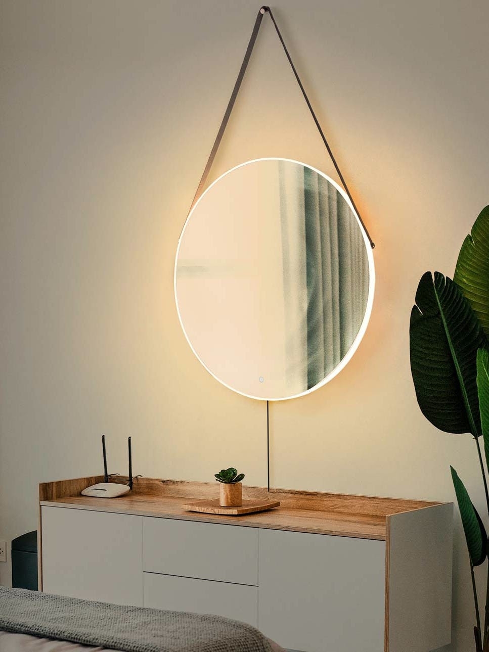 round wall mirror backit by warm LED lights