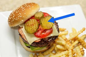 an arrow pointing to pickles on a burger