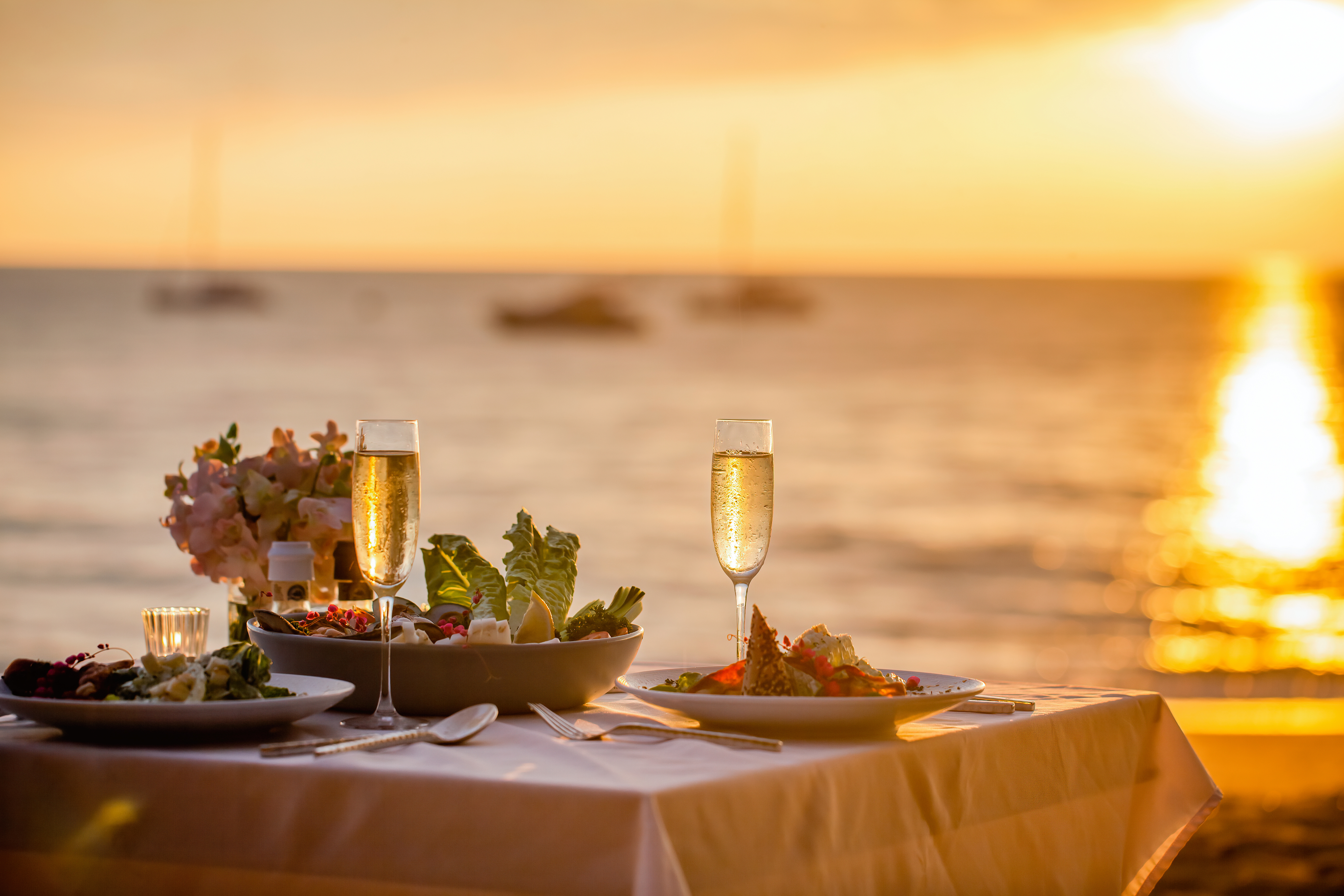 seaside table set for two with fine food and champagne