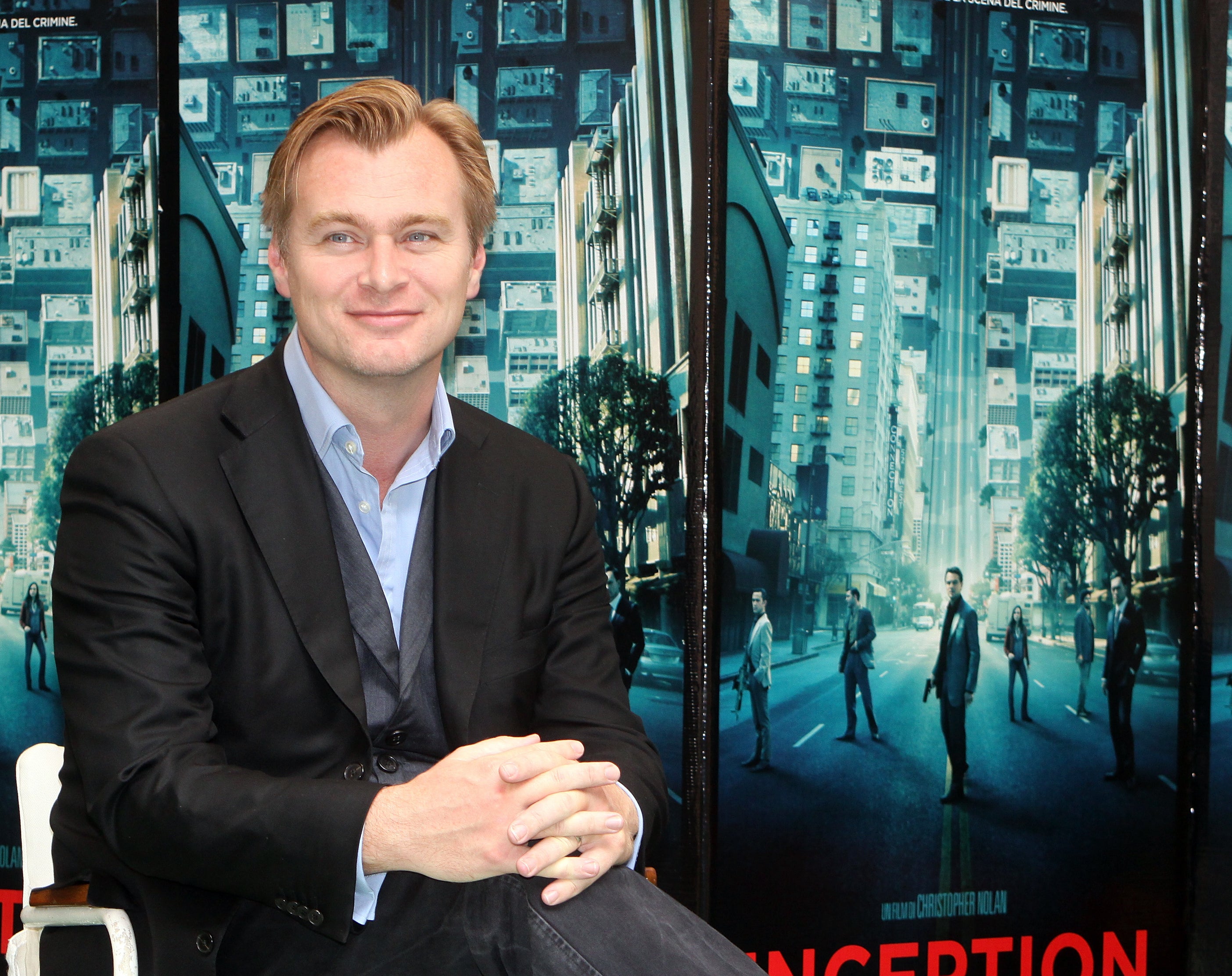 A close-up of Christopher sitting in front of the Inception movie poster