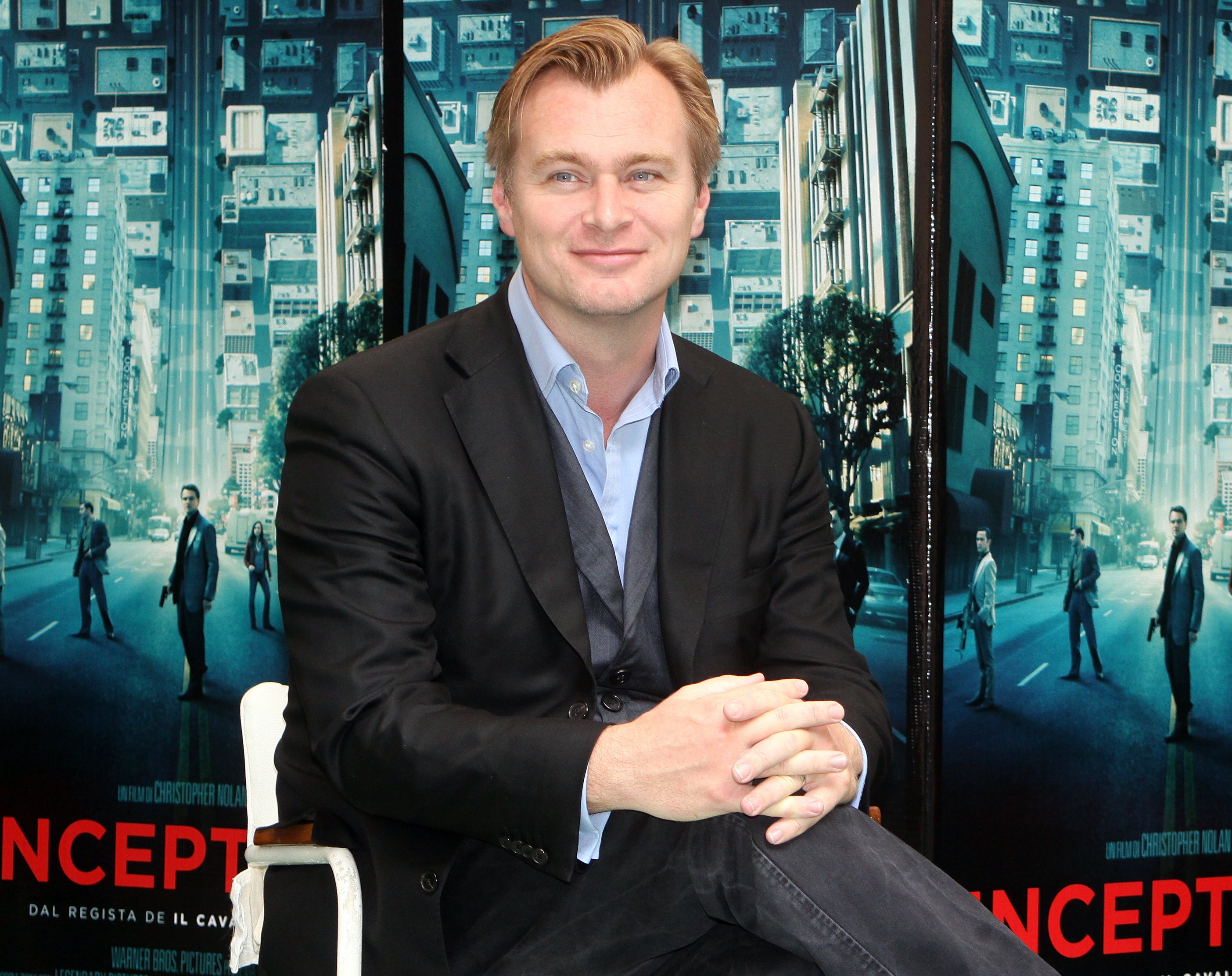 A close-up of Christopher sitting in front of the Inception movie poster