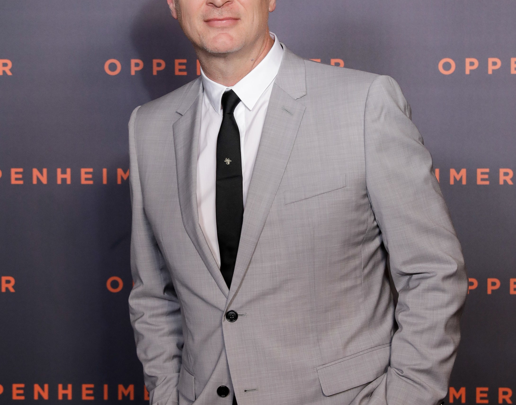 A close-up of Christopher in suit and tie at a media event