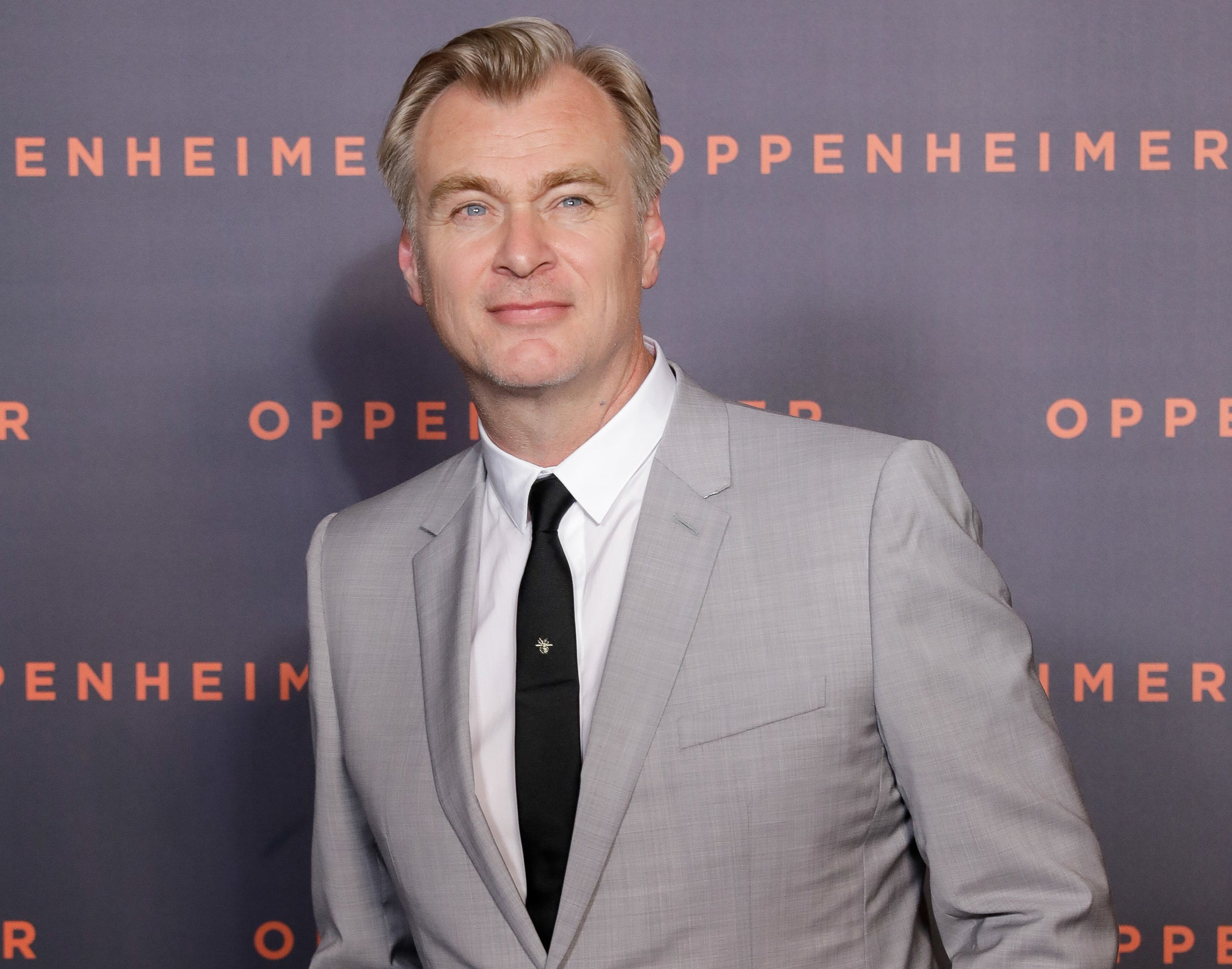 A close-up of Christopher in suit and tie at a media event
