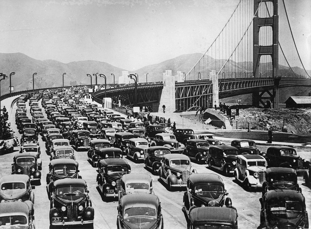 Six lanes packed with very old cars, most of them black, on the bridge