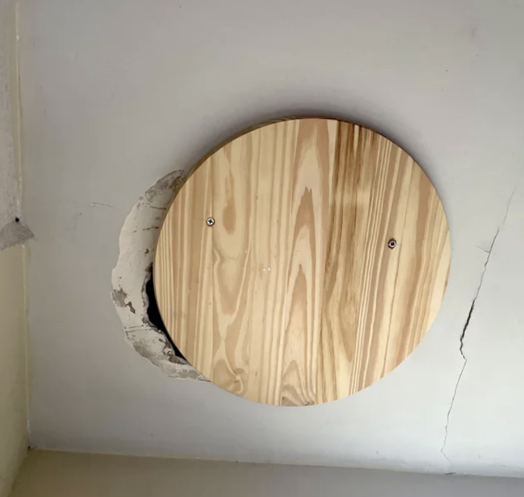 circular wood panel not even covering the entire hole in the ceiling
