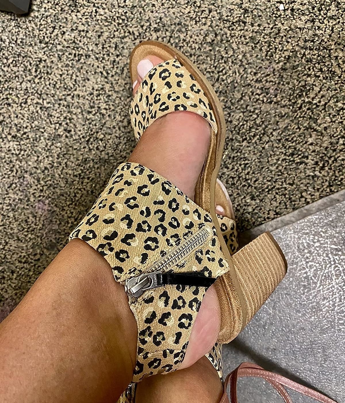 A reviewer wearing animal print sandals