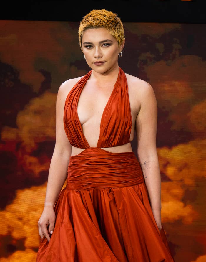Closeup of Florence Pugh on the red carpet in a halter gown with cutouts
