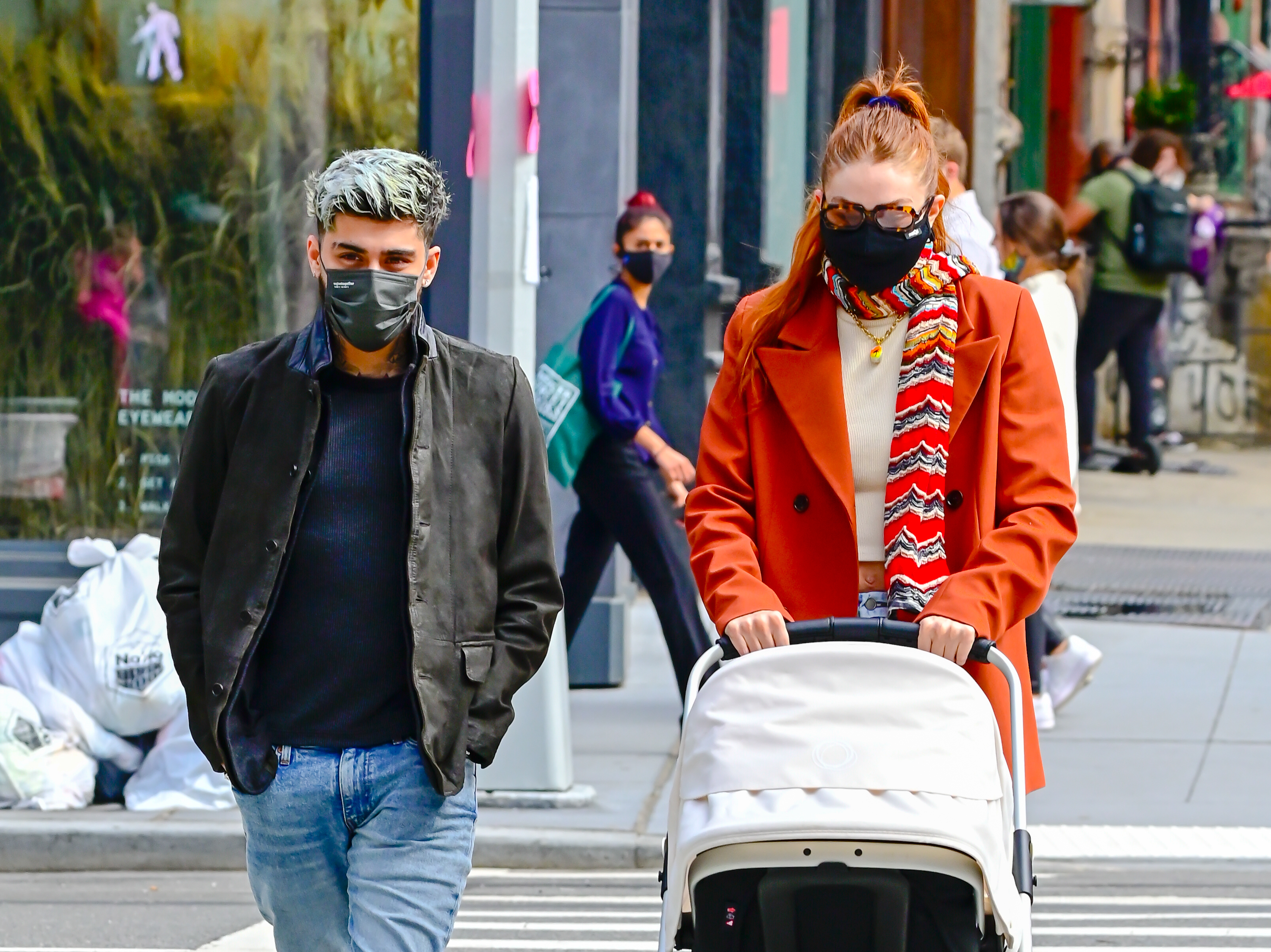 Zayn and Gigi walking their baby down the street