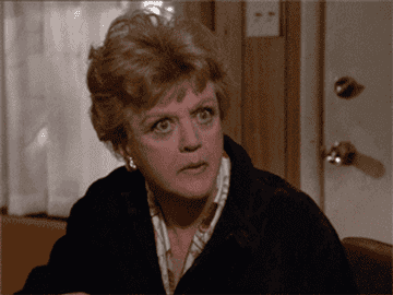 GIF of Angela Lansbury eating popcorn and leaning in in interest