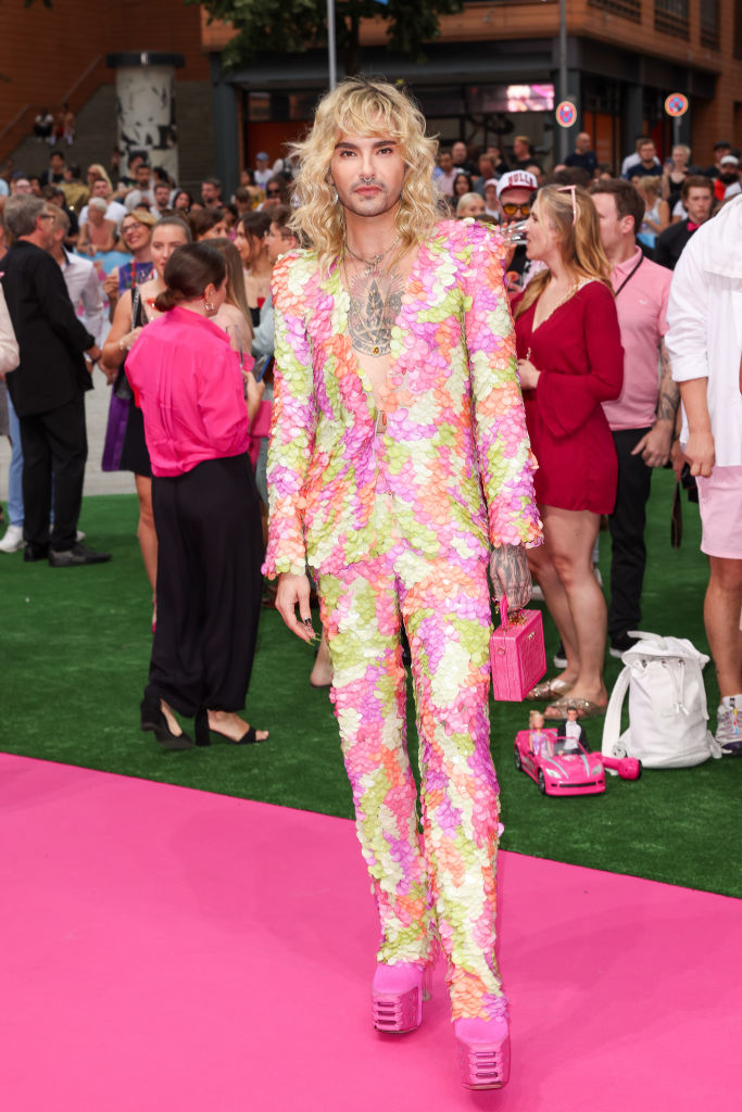 wearing a colorful suit with nothing under the jacket and tall platform pink shoes